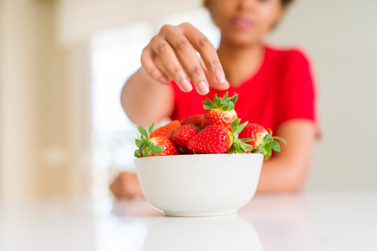 Close up of young woman eating fresh strawberries