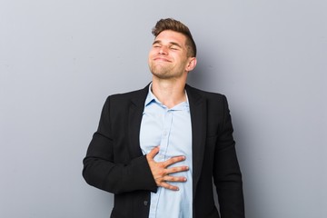 Young handsome caucasian man touches tummy, smiles gently, eating and satisfaction concept.