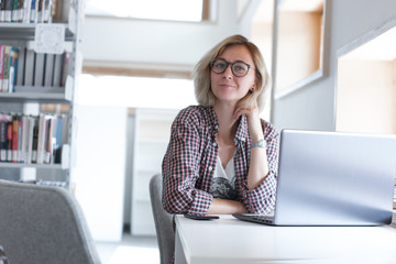 Girl with laptop. Portrait of smiling distance learning student. Online learning distance course. Distance education concept. Teaching. Freelancer girl in modern co-working space. Blogger in library. 