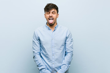 Fototapeta premium Young hispanic business man funny and friendly sticking out tongue.