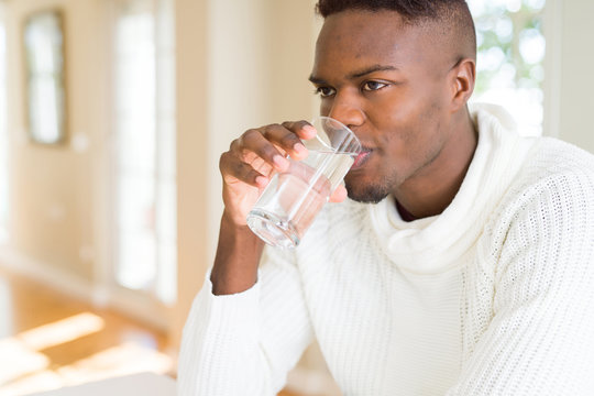Young african american man drinking a fresh glass of water