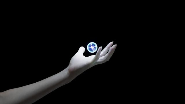Woman's hand with lightning ball in the middle of the screen, 4k footage with special effects on black background