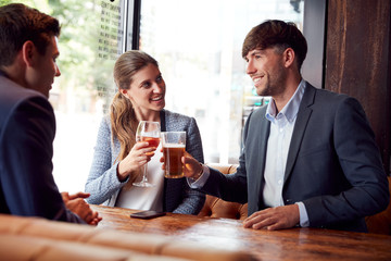 Group Of Business Colleagues Making A Toast As They Meet For Drinks And Socialize In Bar After Work