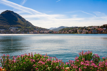 Panorama view of the lake Lugano, mountains and city Lugano, Ticino canton, Switzerland. Scenic beautiful Swiss town with luxury villas. Famous tourist destination in South Europe