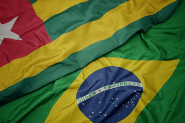 waving colorful flag of brazil and national flag of togo.