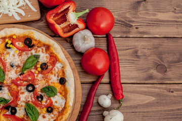 Pizza Margherita or Margarita with Mozzarella cheese, tomato, olive. Italian pizza on wooden background