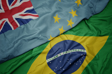 waving colorful flag of brazil and national flag of Tuvalu .