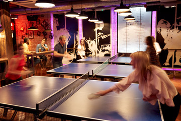 Interior Of Bar With Customers Drinking And Playing Table Tennis - obrazy, fototapety, plakaty