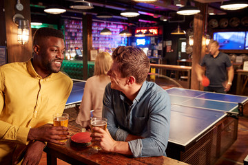 Interior Of Bar With Customers Drinking And Playing Table Tennis