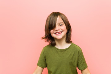 Obraz premium Little caucasian boy playing against a pink background