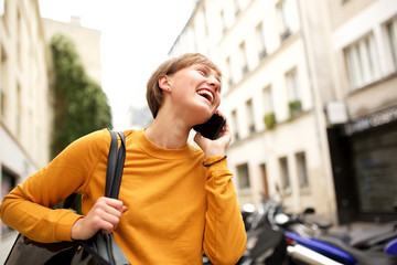 cheerful young woman walking and talking on mobile phone