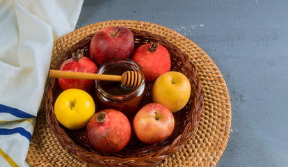 Pouring honey on apple and pomegranate with honey symbols of Jewish New Year - Rosh Hashanah.
