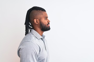 African american businessman with braids standing over isolated white background looking to side, relax profile pose with natural face with confident smile.
