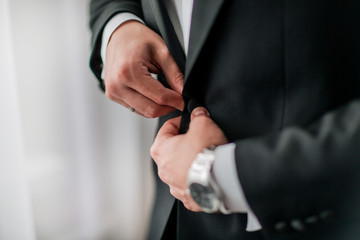 close up. groom buttoning his jacket. holidays and events