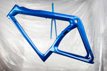 shiny new fresh fresh paintwork coating paint of a metallic blue carbon racing road bicycle frame...