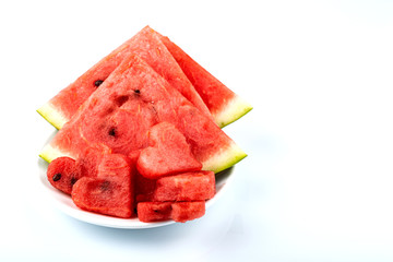 Sliced watermelon in the shape of hearts and ordinary slices on a white background. Copy space.