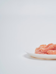 Fresh chicken tenderloin in white plate