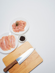 Fresh chicken tenderloin with wooden board, knife.