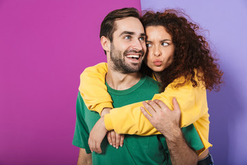 Portrait of positive caucasian couple in colorful clothing smiling and hugging together