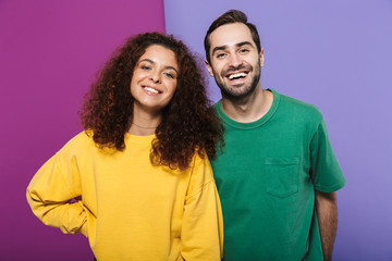 Portrait of beautiful caucasian couple man and woman in colorful clothing smiling together at camera