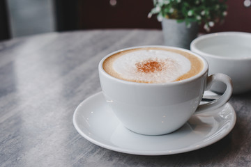 Hot coffee and hot tea place on the marble table in early morning with copyspace, white cup and silver spoon.