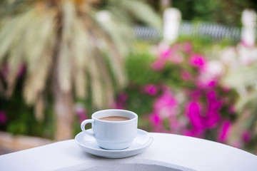 Coffee with milk in a white cup on the balcony of the hotel. The concept of rest and relaxation
