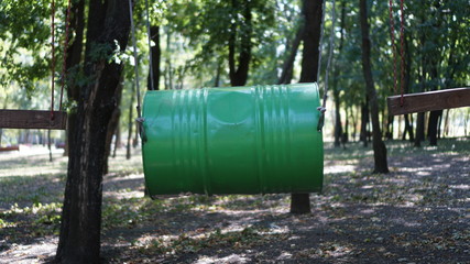 Iron barrrel in a climbing adventure park on a summer sunny day.