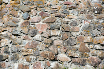 The texture of the ancient stone wall of large cobblestones