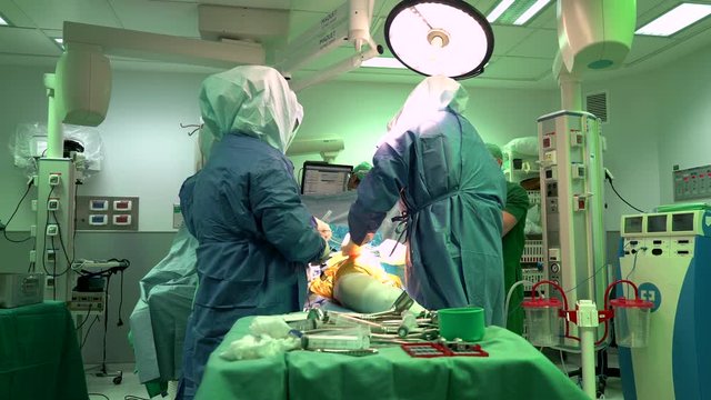Orthopedic surgery. Hospital. Operating room. Professor, doctor, nurses, surgeon. During a medical operation. In sterile green suits