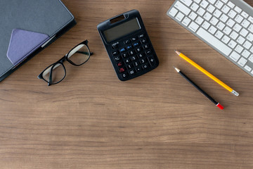 business concept. top view of office desk workspace with calculator, pencil, keyboard and glasses on white table background