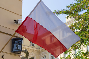 The national flag of poland on the facade of the house.