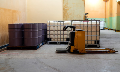 Low light inside of the old factory. The large white and purple tanks chemical packaging.