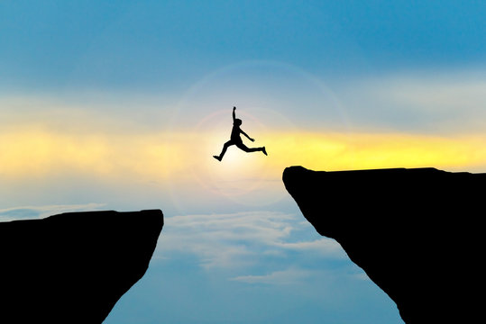 Man jump through the gap between hill.man jumping over cliff