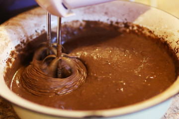 chokolate dough for cake in cooking process with mixer in bowl