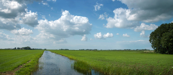 Fototapeta na wymiar Clouds. Dutch polderlandscape near Blokzijl Overijssel Netherlands. Canal.