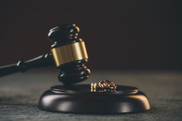 Wedding rings on the figure of a broken heart from a tree, hammer of a judge on a wooden...