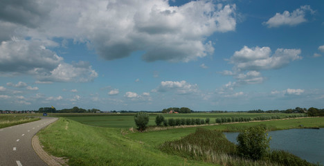 Fototapeta na wymiar Clouds. Dutch polderlandscape near Blokzijl Overijssel Netherlands. Dikes. 