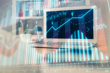 Financial graph colorful drawing and table with computer on background. Double exposure. Concept of international markets.