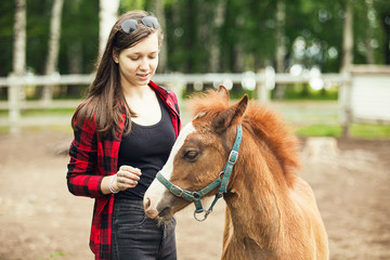 Young girl with the brown foal