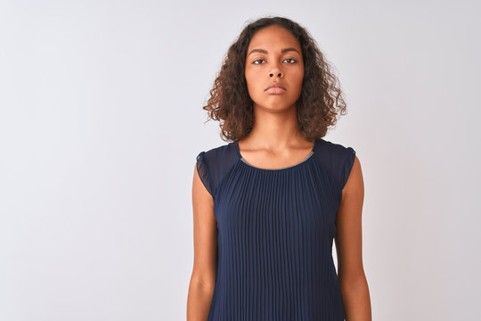 Young brazilian woman wearing blue dress standing over isolated white background Relaxed with serious expression on face. Simple and natural looking at the camera.