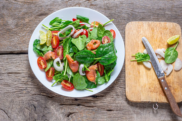 Selective focus Salmon Fresh green Salad with spinach, cherry tomatoes,baby spinach,  Concept for a tasty and healthy meal. Dark stone background. Top view. Close up.