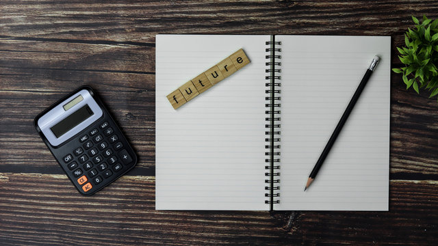 future alphabet, calculator and a notebooks on the wooden table in the office.