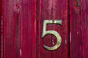 House number 5 on an old wooden door