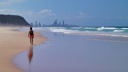 Surfers Paradise. City view form a beach with skyscraper and hotels and walking woman. Gold Coast Queensland Australia.