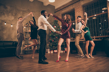 Fototapeta na wymiar Full size low angle photo of excited fellows with brunette red curly hair dance club on christmas party x-mas holidays wear dress skirt stilettos white shirt in house with newyear lights indoors