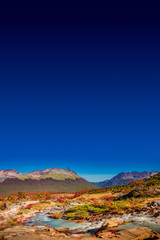 Fototapeta premium Panoramic view of magical colorful fairytale forest at Tierra del Fuego National Park with a lonely hiker, Patagonia, Argentina, Autumn time, blue sky