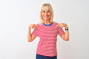 Middle age woman wearing casual striped t-shirt standing over isolated white background looking confident with smile on face, pointing oneself with fingers proud and happy.