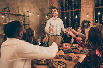 Portrait of nice attractive handsome smart stylish cheerful cheery glad positive guys having fun eve noel tradition midnight dream wish saying toast enjoying leisure in decorated house room