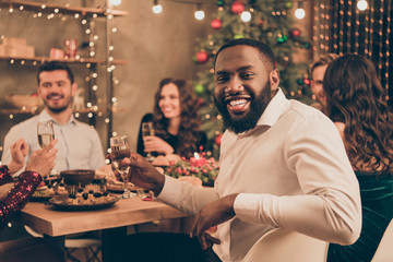 Portrait of nice attractive lovely well-dressed smart stylish cheerful cheery positive glad multinational guys having fun spending festal event winter December occasion in decorated house room