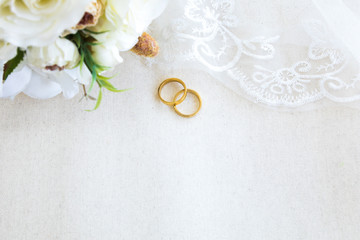 Beautiful top view flat lay a pair of gold rings necklace and beautiful flower bouquet on white background, wedding celebration or valentines concept